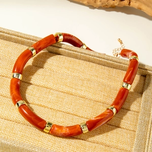 Macro detail of acrylic marble tube bracelet with golden metallic spacer beads