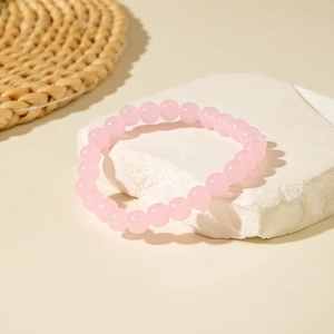 Detailed view of round pink crystal beaded bracelet on white textured stone background