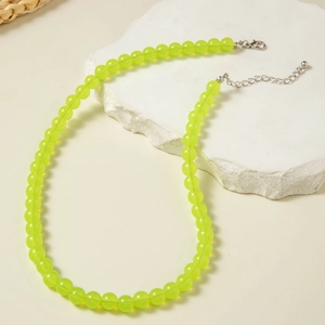 Detail of neon green acrylic beaded necklace with silver lobster clasp and extension chain