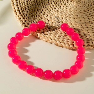 Fashionable vibrant pink acrylic beaded necklace with silver clasp on a woven mat