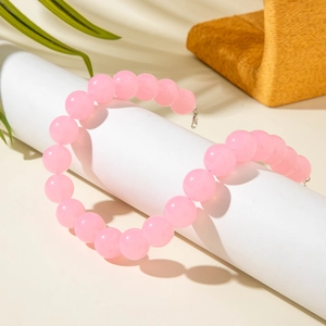 Chic pink acrylic beaded necklace with silver lobster clasp on a stylish prop