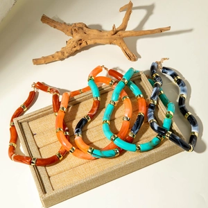 Chic acrylic tube bracelets with marble texture and golden metal spacers on display