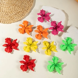 Detailed view of colorful matte flower earrings in red yellow green and orange shades