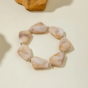 Détails de perles acryliques irrégulières marbrées et entretoises argentées sur un bracelet