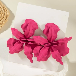 Macro detail of large matte fuchsia floral earrings with irregular 3D petal textures