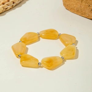 Détail de perles en résine jaune irrégulières sur un bracelet bohème avec séparateurs