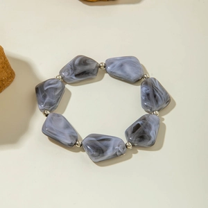 Détail macro du bracelet bohème avec perles marbrées grises et accents argentés