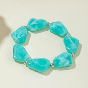 Détail de perles irrégulières en acrylique vert avec intercalaires argentés