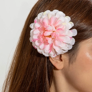 Détail d'une grande pince à cheveux dahlia rose 3D portée par un mannequin pour un style d'été