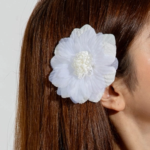 Détail d'une pince à cheveux fleur en polyester 3D blanc sur cheveux bruns