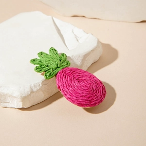 Gros plan détaillé sur la pince à cheveux ananas 3D en tricot rose et vert