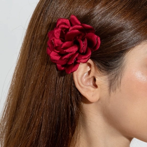 Vue détaillée d'une pince à cheveux fleur rouge foncé en polyester 3D sur cheveux