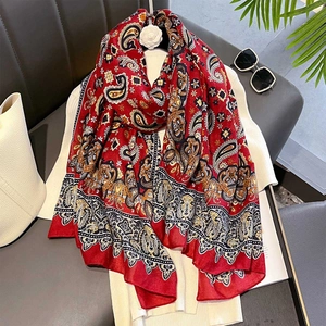 Red paisley print vintage shawl with fringe detail styled with a bag and sunglasses
