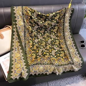 Detail of dark green paisley pattern on high-quality silk-like scarf with ethnic borders