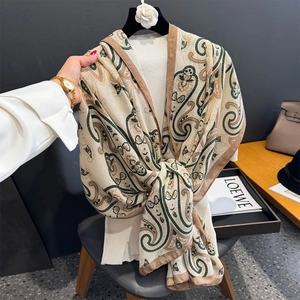 Détail d'une écharpe à motif cachemire en coton et lin doux dans les tons beige et vert