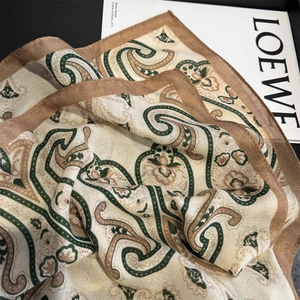 Détail macro d'une écharpe à motif paisley avec texture soyeuse et bordures