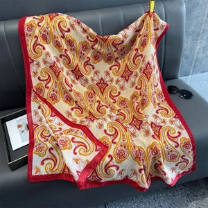 Détail d'une écharpe à motif cachemire doux avec bordure rouge sur un canapé