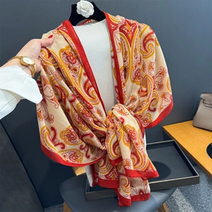 Gros plan du foulard en coton et lin au motif paisley rouge et beige doux