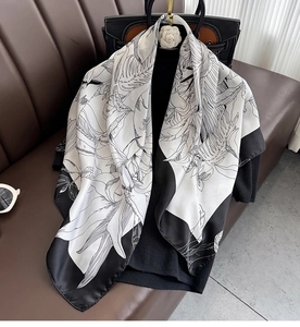Détail d'un foulard en soie à imprimé floral drapé élégamment sur un sac à main chic