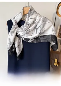 Détail d'un foulard carré en soie à imprimé floral vintage élégamment drapé sur une robe