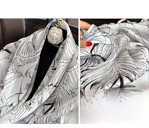 Détail de la texture soyeuse et de l'imprimé floral monochrome sur ce foulard carré