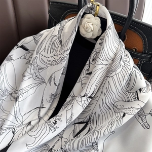 Carré de soie blanc vintage à imprimé floral avec broche camélia sur un sac de créateur