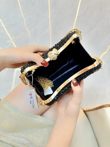 Detail der schwarzen Strass-Abendtasche mit Goldrahmen und Perlen-Schleifenverschluss
