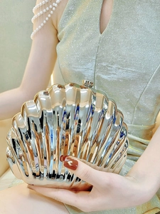 Detail of shell-shaped evening bag in champagne gold with polished metallic rib texture