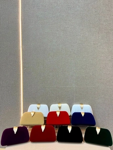 Detailed view of luxury velvet evening clutch bags in multiple colors with leaf clasp