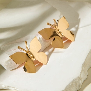 Macro d'oreilles papillon dorées à l'éclat métallique sur une pierre texturée blanche