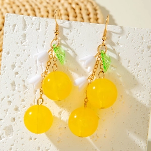 Detail of lily of the valley earrings with yellow beads and golden hooks on stone