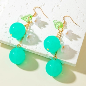 Detailed view of handmade cherry earrings with green leaves and white flowers