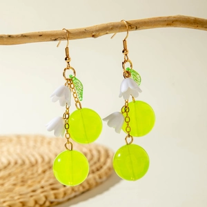 Detail of Lily of the Valley earrings with green acrylic grapes on a wooden branch