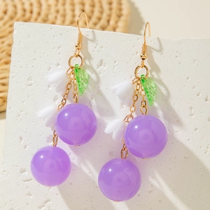 Macro detail of cherry-style drop earrings with purple beads and green leaf accents
