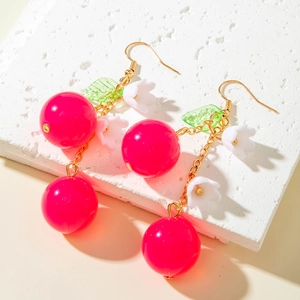 Detail of cherry earrings with pink beads, white flowers and green leaves on stone