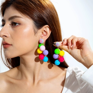 Close-up of vibrant multi-color beaded drop earrings on model for a summer look