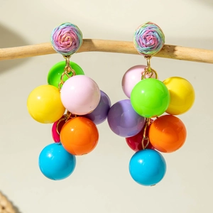 Macro shot of bohemian colorful beaded cluster earrings with woven rose detail on wood