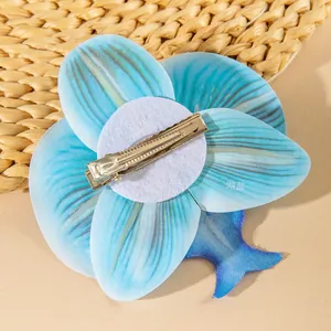 Detail of lake blue orchid hair clip showing secure metal duckbill clip back mechanism