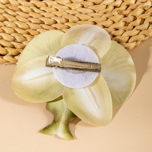 Macro shot of orchid petal hair clip with detailed leaf veins and metal duckbill clip