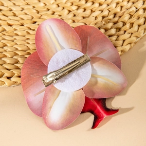 Detail of the back of a pink orchid flower clip showing the silver metal alligator clip