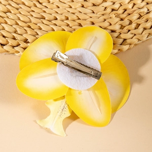 Detail of yellow frangipani flower hair clip with silver metal alligator clasp on back