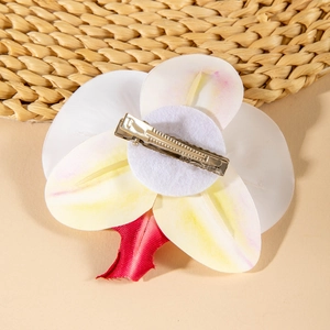 Detail view of tropical white orchid hair clip with metal duckbill clip and felt base