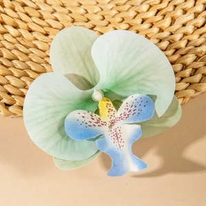 Detailed close-up of a gradient mint green orchid hair clip with a faux pearl center