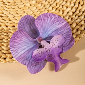 Detailed macro view of purple orchid hair clip with realistic fabric texture and spots
