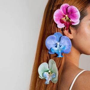 Three colorful orchid flower hair clips in pink, blue, and cyan for beach vacations