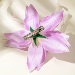 Close-up of lily hair clip back featuring a metal alligator clip and green floral calyx
