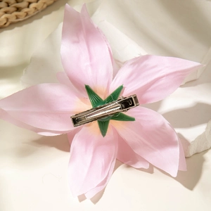 Detail of pink lily hair clip with silver crocodile clip and green base for women