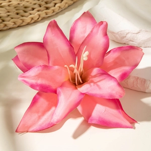 Realistic gradient pink lily flower hair clip with textured petals on a natural mat