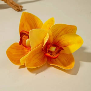 Detail view of artificial orange lily hair clip with purple spotted core on white background