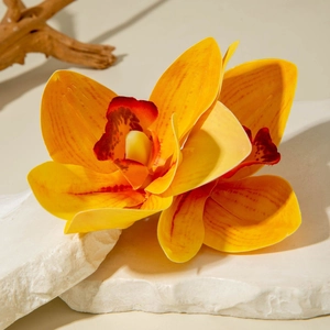 Close-up of realistic orange orchid lily hair clip texture on a natural stone base
